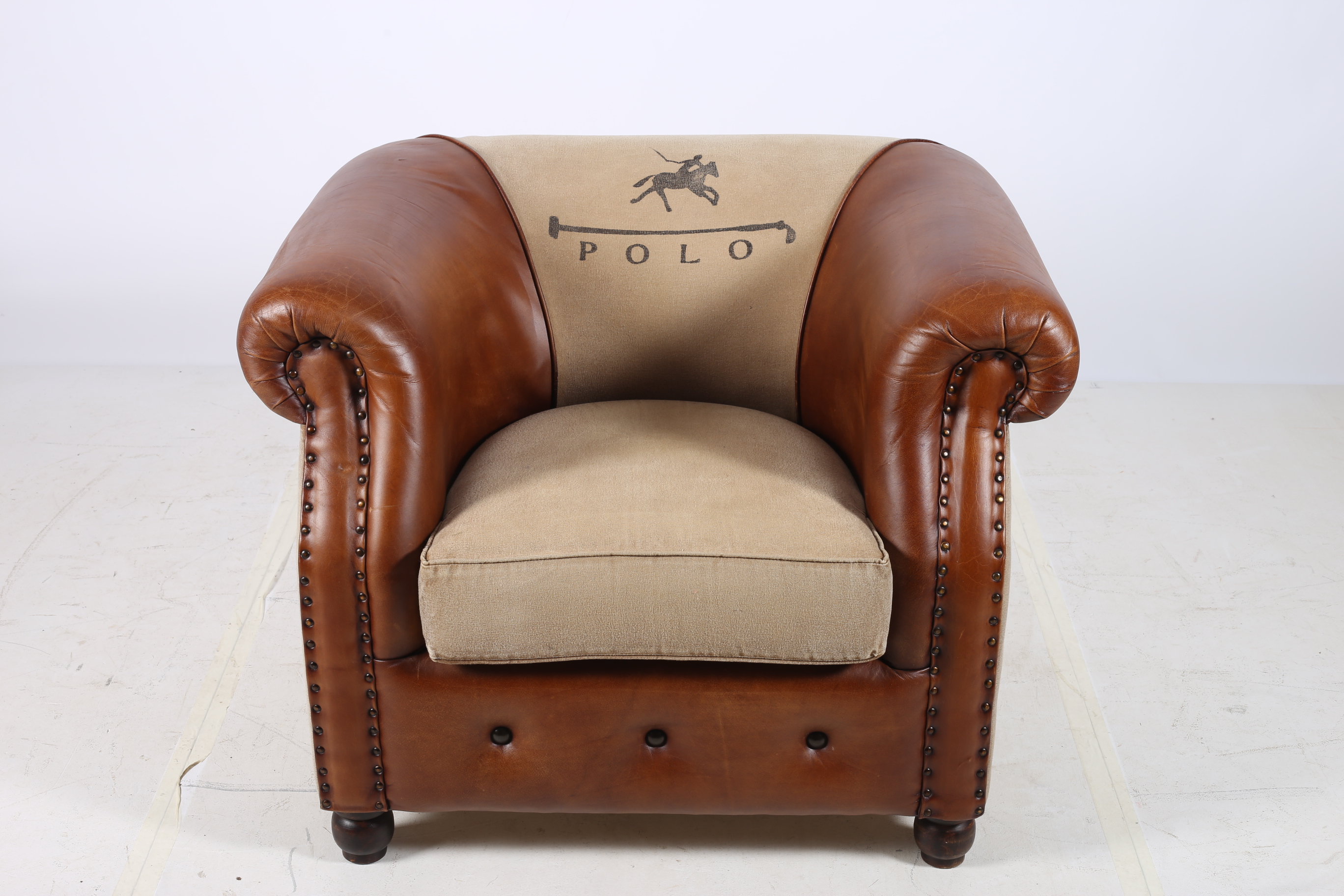 A VICTORIAN DESIGN ARMCHAIR with scroll over back and arms and loose cushion inscribed Polo on bun