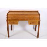 AN OAK ROLL TOP DESK the tambour shutter containing pigeon holes and drawers with tooled leather