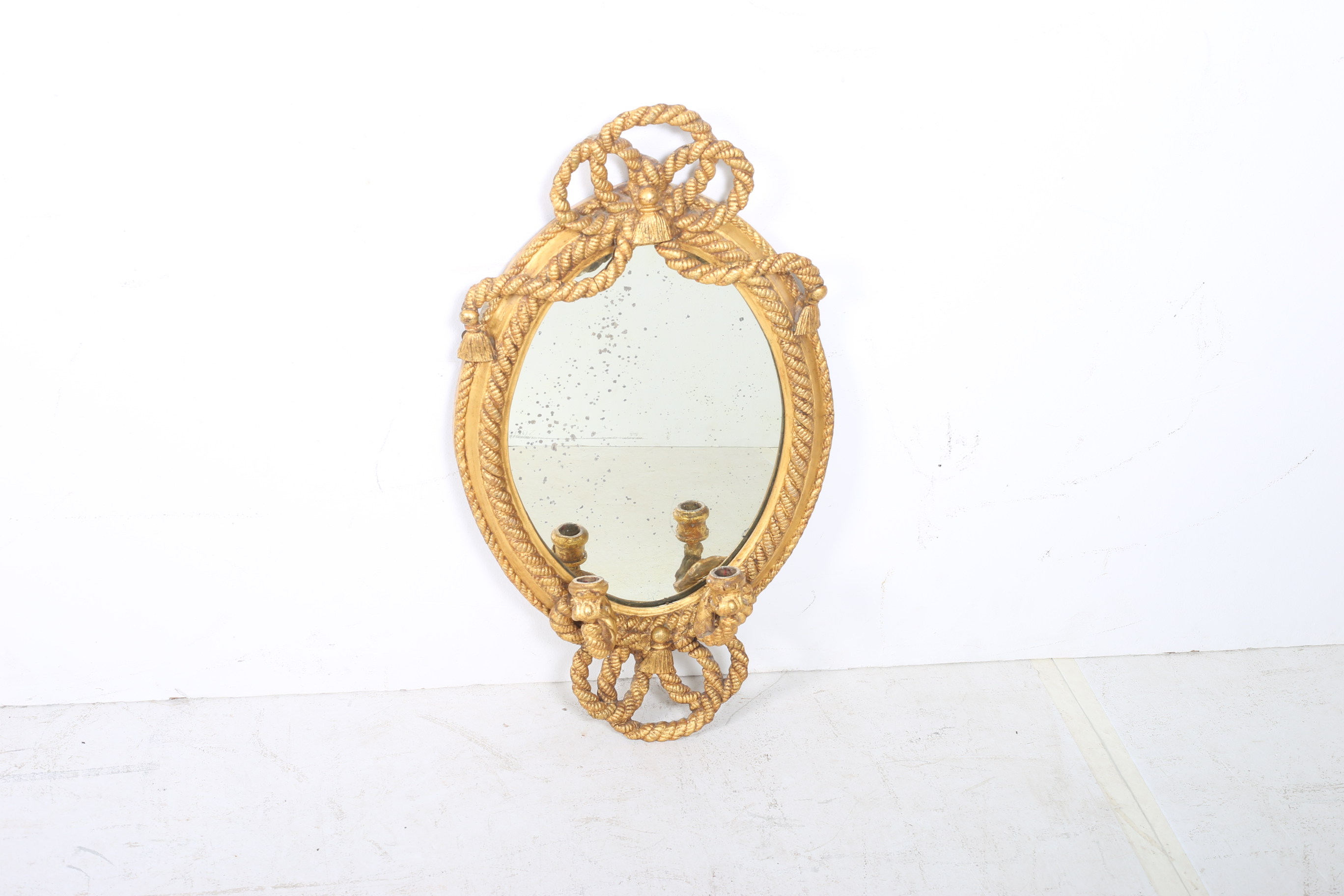 A CONTINENTAL GILT FRAME GIRANDOLE MIRROR the oval plate within a moulded frame with ribbon tied