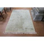 A BEIGE AND LIGHT GREEN GROUND PATTERNED RUG the central panel with stylized flower heads and