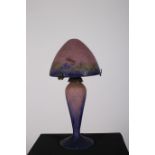 AN ART DECO MULTICOLOURED GLASS TABLE LAMP with mushroom shade above a baluster column on circular