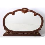 A CONTINENTAL SIMULATED AND GILT FRAME OVERMANTLE MIRROR the oval plate within a C scroll and shell