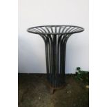 A WROUGHT IRON BRAZIER of cylindrical form with slatted uprights on scroll supports 77cm (h) x 52cm