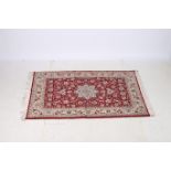 A VERY FINE AFGHAN WOOL RUG the wine and beige ground with central panel filled with flower heads