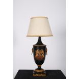 A TOLEWARE TABLE LAMP of urn form decorated with coat of arms and brass lion mask ring handles with