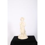A WHITE MARBLE FIGURE modelled as a young child holding a shawl shown standing on a naturalistic