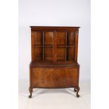 A CIRCA 1950s MAHOGANY DISPLAY CABINET the moulded cornice above a pair of glazed doors containing