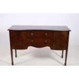 A HEPPLEWHITE DESIGN MAHOGANY SIDEBOARD of serpentine outline the shaped top with two frieze