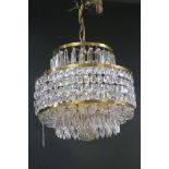 A WATERFORD CUT GLASS AND BRASS CENTRE LIGHT hung with faceted chains and pendent drops