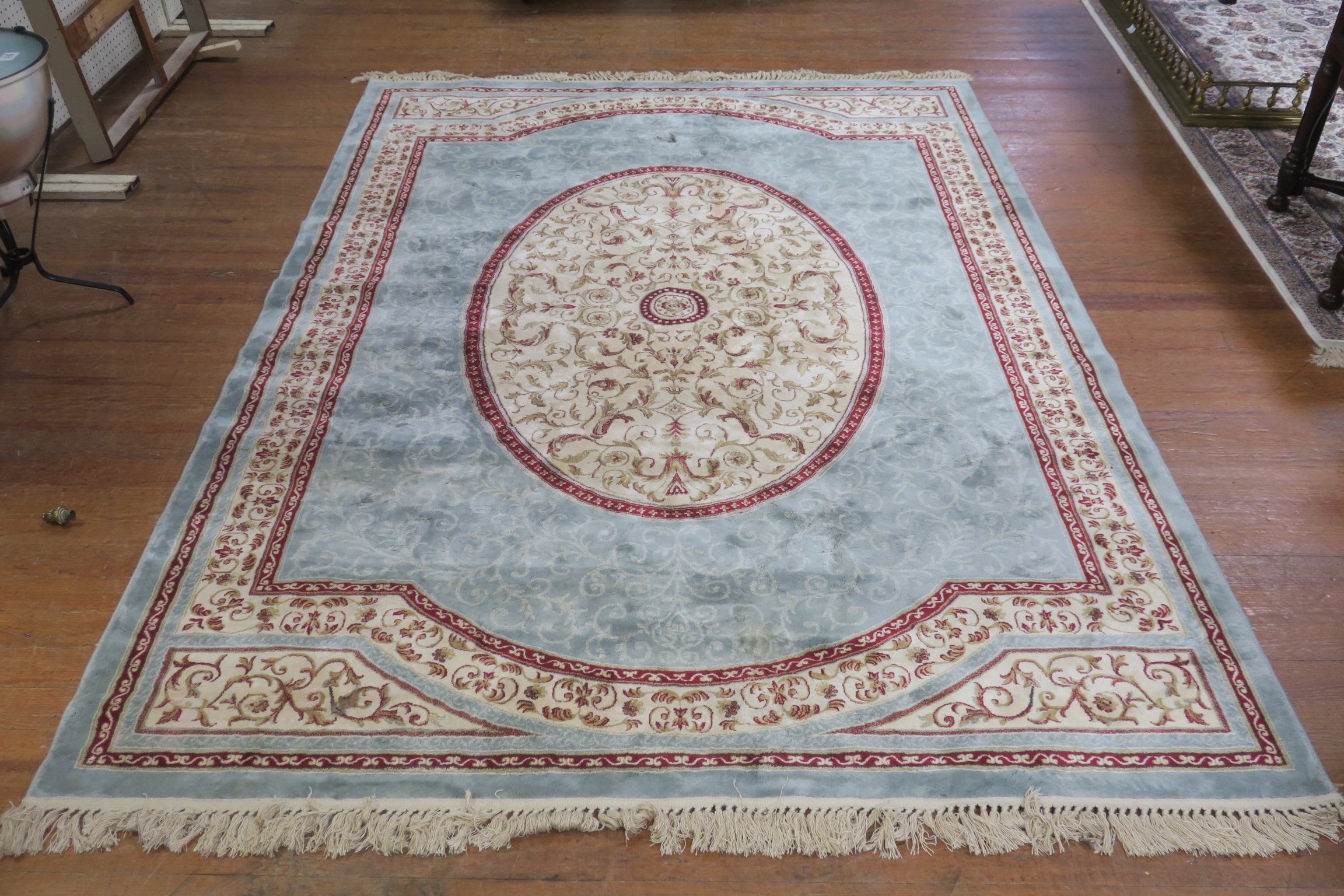 A LIGHT BLUE AND BEIGE GROUND PATTERNED RUG the central panel filled with stylized foliage and