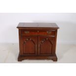 A MAHOGANY SIDE CABINET the rectangular hinged top with frieze drawer and cupboards on bracket feet