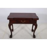 A GEORGIAN DESIGN MAHOGANY FOLD OVER GAMES TABLE of inverted breakfront outline the shaped top with