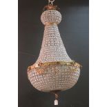 A CONTINENTAL GILT BRASS AND CUT GLASS CHANDELIER hung with faceted pendants