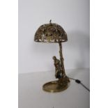 A BRASS FIGURAL TABLE LAMP modelled as a young girl shown standing holding a jug beside a tree