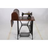 AN OAK CASE SINGER SEWING MACHINE on cast iron base 102cm (h) x 101cm (w) x 41cm (d)