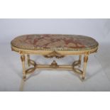 A CONTINENTAL CREAM PAINTED PARCEL GILT COFFEE TABLE of oval outline surmounted with a veined
