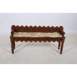 AN OAK GOTHIC DESIGN HALL SEAT the carved back and plank seat with knopped arms on conforming legs