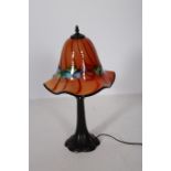 AN ART DECO DESIGN BRONZED TABLE LAMP the multicoloured mushroom shaped shade above a spreading
