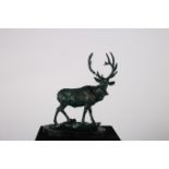 A CAST IRON AND POLYCHROME FIGURE modelled as a deer shown standing on a naturalistic base on an