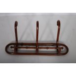 A BENTWOOD THREE HOOK WALL MOUNTED COAT AND HAT HANGER 29cm (h) x 70cm (w)