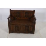 A GOTHIC DESIGN MAHOGANY HALL SEAT the rectangular carved back above a hinged seat with moulded