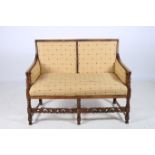 A JACOBEAN STYLE OAK TWO SEATER SETTEE the shaped top rail with upholstered panels and seat and