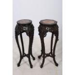 TWO ORIENTAL CARVED JARDINIERE STANDS each with a rouge veined marble inset above a pierced frieze