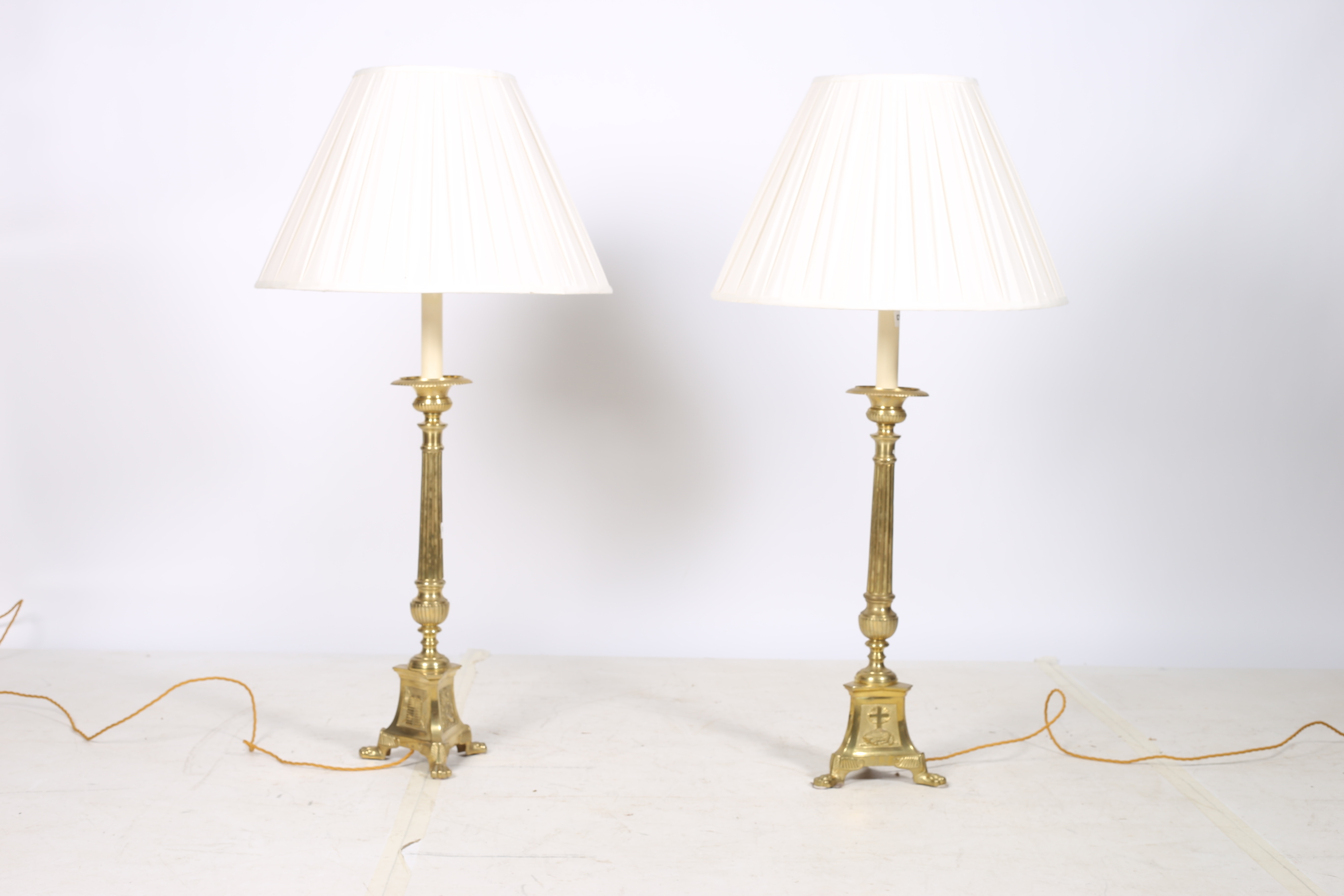 A GOOD HEAVY PAIR OF BRASS TABLE LAMPS each with a reeded column above a triform base with claw