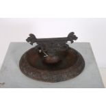 A 19TH CENTURY CAST IRON FOOT SCRAPE of oval dish form with dog head finials 16cm (h) x 32cm (w) x