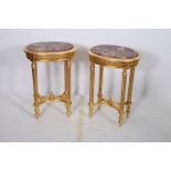 A PAIR OF CONTINENTAL GILTWOOD TABLES each of oval outline surmounted by a rouge veined marble
