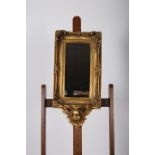 A CONTINENTAL GILT FRAMED MIRROR the rectangular bevelled glass plate within a C-scroll and flower