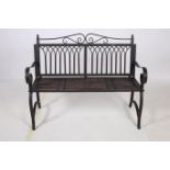 A WROUGHT IRON GARDEN BENCH the scroll top rail above Gothic design splats with slatted seat and