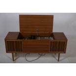 A TEAK CASE RADIOGRAM of rectangular outline with hinged lid on cylindrical tapering legs 56cm (h)