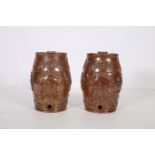 A PAIR OF GLAZED POTTERY WINE BARRELS each moulded in relief with fruiting vines and figures of