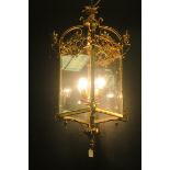A CONTINENTAL GILT BRASS AND GLAZED FOUR LIGHT HALL LANTERN of square form with pierced cresting