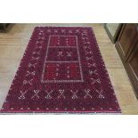 A FINE AFGHAN KUNDUZ WOOL RUG the wine ground with central panel filled with lozenges palmettes and