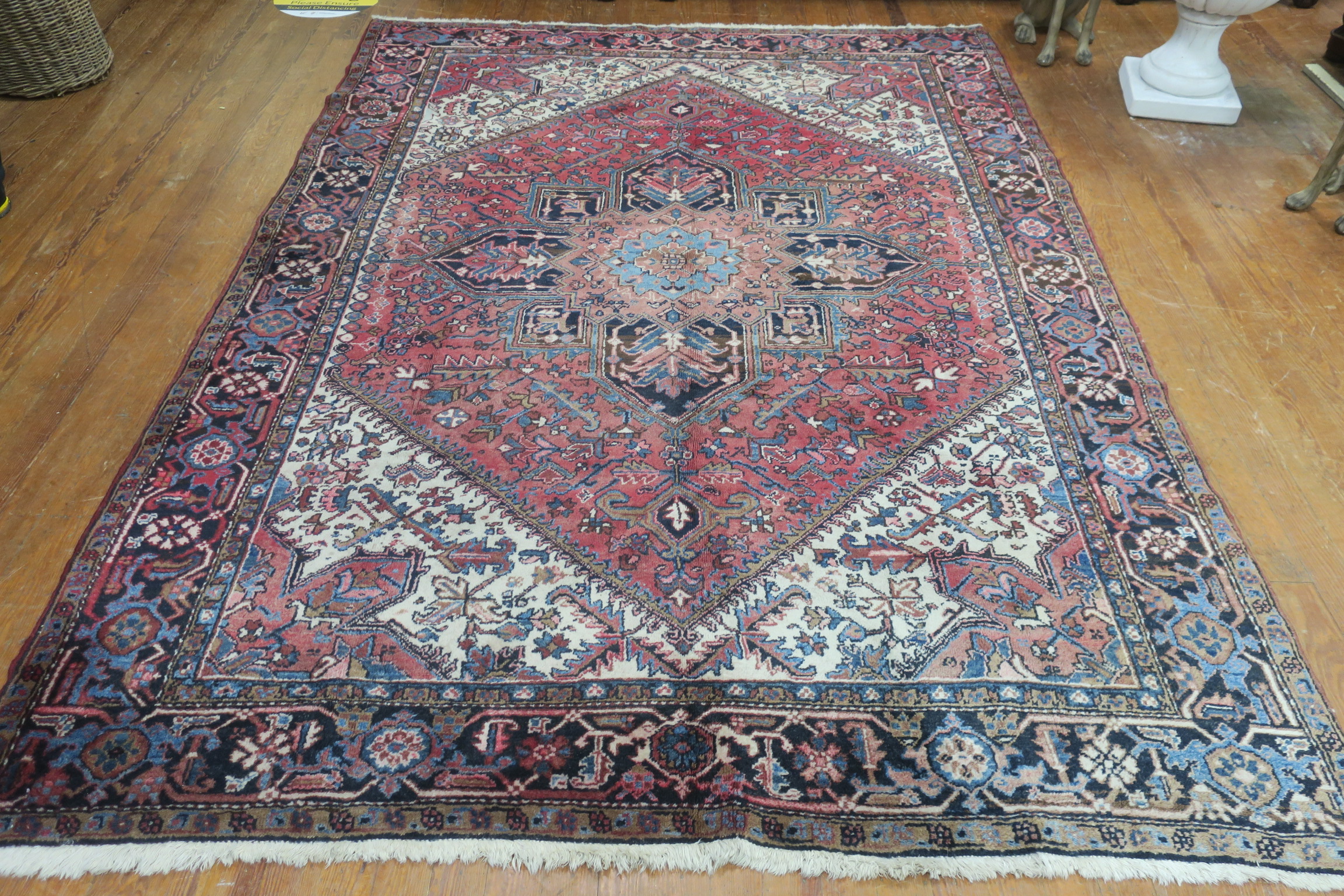 A HERIZ VINTAGE WOOL RUG the light pink beige and light blue ground with central panel filled with