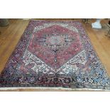 A HERIZ VINTAGE WOOL RUG the light pink beige and light blue ground with central panel filled with