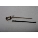 A BRASS AND STEEL LETTER OPENER in the form of an officer's sword in a brass patinated sheath
