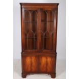 A GEORGIAN DESIGN MAHOGANY CORNER CABINET of concave outline the dentil moulded cornice above a
