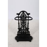 A CAST IRON STICK STAND the arched top above a C-scroll and flower head pierced back plate above a