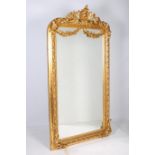 A CONTINENTAL GILT FRAMED MIRROR the rectangular bevelled glass plate within a C-scroll flower head