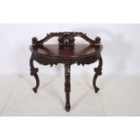 A MAHOGANY SIDE TABLE of demilune outline with carved back and frieze on cabriole legs with scroll