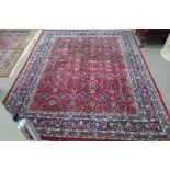 A SAROUK WOOL RUG the wine and light blue ground with central panel filled with flower heads