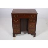 A GEORGIAN MAHOGANY DESK of rectangular outline the shaped top with frieze drawer and six short