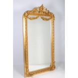 A CONTINENTAL GILT FRAMED MIRROR the rectangular bevelled glass plate within a C-scroll flower head