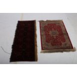 AN ORIENTAL WOOL RUG the wine ground with central diamond shaped panels filled with scrolls and