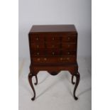 A MAHOGANY CHEST ON STAND of rectangular outline the shaped top with four long drawers on moulded