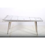 A WHITE METAL AVIATION TABLE in the form of an aeroplane wing the shaped top with metal rivets