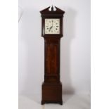 A GEORGIAN MAHOGANY LONG CASE CLOCK the architectural pediment above a painted dial with Roman